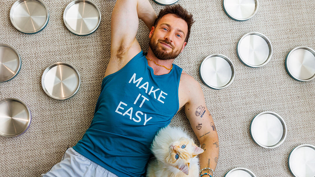 Sam Thompson lying on the floor with his cat